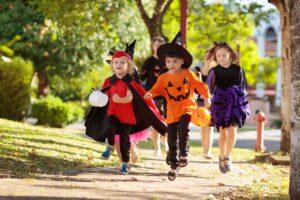 A group of young children run along the sidewalk while trick-or-treating. Contact a personal injury lawyer to learn about 10 trick or treat safety tips for pedestrians and drivers.