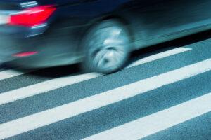 Pedestrian crossing with car in the background. Find out what the average pedestrian accident settlement is worth.